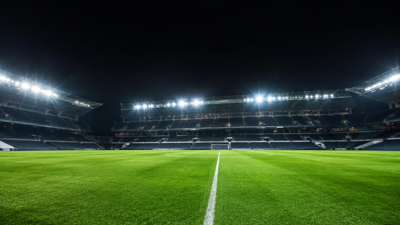 Football pitch under stadium floodlights